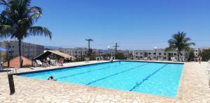 圣佩德罗-达阿尔德亚Residencial Marina Club的一座种植了棕榈树和建筑的大型蓝色游泳池