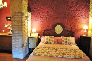 科尔努德利亚Masia El Canalot - Molí Del Pont的一间卧室配有一张红色墙壁的床