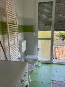 菲纳莱利古雷Appartamento Libeccio的一间带卫生间和浴缸的浴室以及窗户。