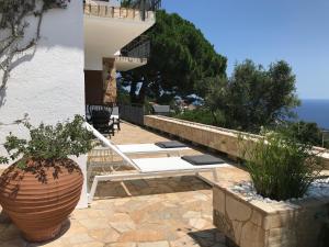 罗列特海岸Villa Panorama 360的庭院设有白色长凳和花瓶。