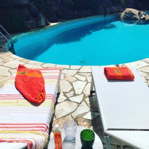罗列特海岸Villa Panorama 360的游泳池配有白色桌子和红色毛巾
