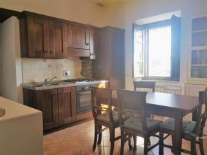 特拉西梅诺湖畔帕西尼亚诺Ryan Apartment的厨房配有木制橱柜和桌椅