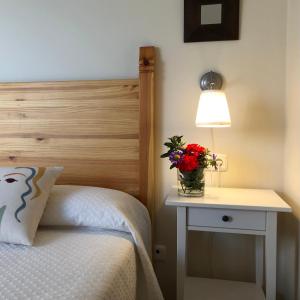 莫利纳塞卡Casa Rural Maria的一间卧室配有一张床和一张桌子,配有灯和鲜花