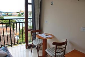 特里温福Pousada Solar Do Triunfo的带阳台的客房内的一张桌子和两把椅子