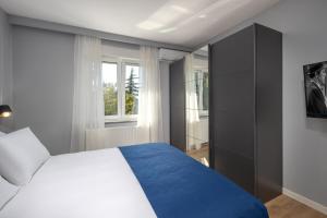 里耶卡Blue Allure Apartment的一间卧室设有一张床和一个窗口