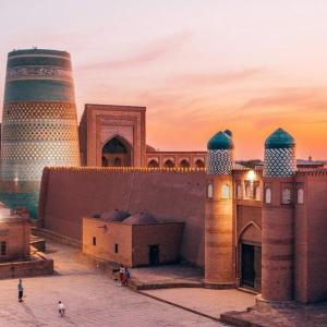希瓦Khiva Ibrohim Guest House的享有清真寺的两座塔楼和一座建筑的景色