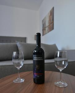 弗尔尼亚奇卡矿泉镇Lux Pegaz 008的一张桌子上摆放着一瓶葡萄酒和两杯酒杯