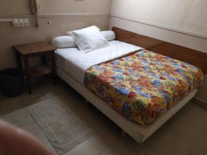 巴黎A la Pinte du Nord的一间卧室配有一张床和一个带床罩的床头柜。