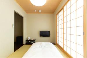 京都烏丸六条酒店的一间带大床和电视的卧室