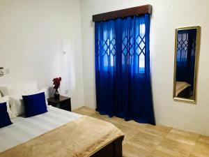 MadinaMoroccan Tile House - Tranquil Estate - Boundary Rd的一间卧室配有一张带蓝色窗帘和镜子的床