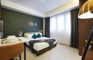 新加坡The Initial Residence的一间卧室配有一张床、一张桌子和一个窗户。