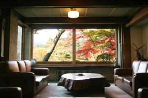日光日光金谷酒店 的客厅设有大窗户和茶几