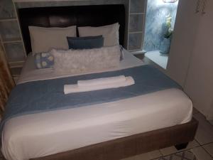 约翰内斯堡Corgi Guest House的一张大床,上面有两条白色毛巾