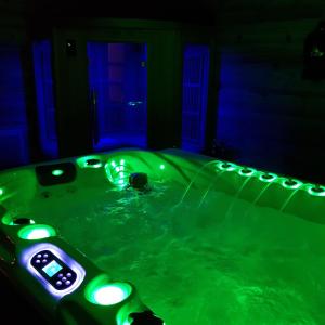圣谢利多布拉克AUBRAC Spa的暗室里带灯的绿色浴缸