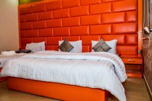 卡拉奇Clifton Rezidor的配有橙色床头板的客房内的两张床