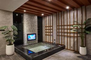 台中市木木行馆的带浴缸的浴室以及电视。