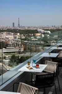 库尔布瓦巴黎狄芬思美利亚酒店的市景阳台配有桌椅