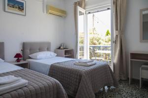 斯派赛斯Argonaftis Spetses的酒店客房设有两张床和一个阳台。