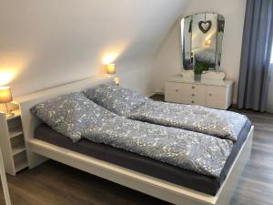 WeisweilHaus Blum的卧室内的一张床位,配有镜子和灯