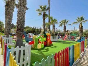 阿默达拉-伊拉克利翁米诺雅公寓酒店的一个带棕榈树的色彩缤纷的公园的游乐场