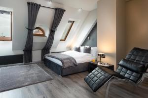 弗罗茨瓦夫Aparthotel New Lux的一间卧室配有一张床和一把椅子