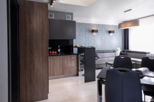弗罗茨瓦夫Aparthotel New Lux的厨房以及带桌椅的起居室。