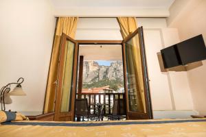 卡兰巴卡Famissi Hotel的卧室设有通往阳台的门