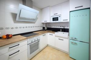 普拉森西亚Apartamento Boutique Plasencia Centro的厨房配有白色橱柜和蓝色冰箱。