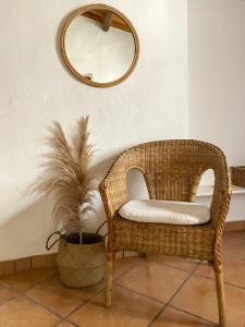 SolarussaIs Scabas Guestrooms的一张柳条椅,坐在一个带镜子的房间