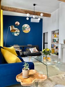 尼姆Grand confort au cœur de Nîmes的客厅设有蓝色的墙壁和蓝色的沙发。