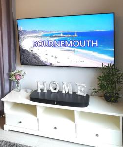 伯恩茅斯Modern House in Bournemouth town centre的电视坐在白色电视架上