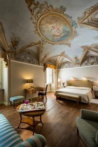 圣马蒂诺坎波Posta Donini 1579 - UNA Esperienze的客房设有带一张床铺和一张桌子的天花板。