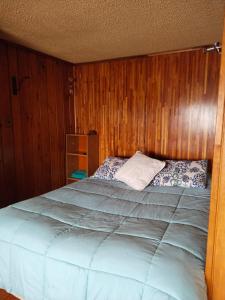 蒙特港lotus shared-house的一间卧室配有一张带木墙的大床