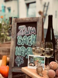 阿尔肯Zum Bachhexje的一张桌子,上面放着两杯葡萄酒和黑板