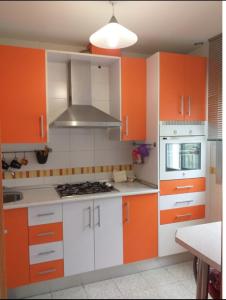 格拉纳达Disfruta Granada,incluso con tu mascota Parking的橙色和白色的厨房,配有白色的橱柜