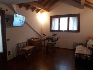 阿贝托内Grande appartamento I Faggi的客厅配有桌子和墙上的电视