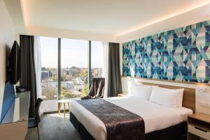 基督城Carnmore Hotel Christchurch的酒店客房设有一张床和一个大窗户