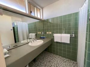 阿德莱德Haven Marina Motel的绿色瓷砖浴室设有水槽和镜子