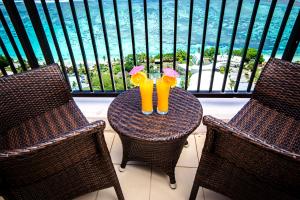 塔穆宁Pacific Islands Club Guam的阳台上的桌子上放着两只黄玻璃杯