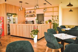 RinasAirport Garden Hotel的一间带桌椅和柜台的餐厅