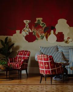 勒布斯卡Hôtel Maison Pavlov的客厅设有两把椅子和红色的墙壁