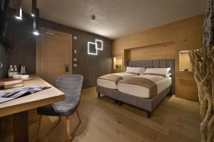 利维尼奥孔帕尼奥尼酒店的卧室配有一张床、一张桌子和椅子