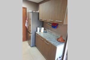 诺阿瑟Apartment Near & close to Casablanca Mohammed V International Airport的厨房配有木制橱柜和冰箱。