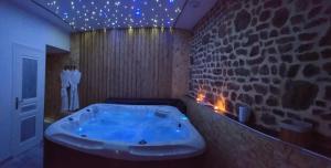 Lonlay-lʼAbbayeLe Ptit Spa de L'Abbaye Suite love et Spa privé的石墙客房内的浴缸