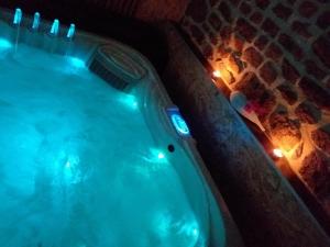 Lonlay-lʼAbbayeLe Ptit Spa de L'Abbaye Suite love et Spa privé的客房内的按摩浴缸配有灯光