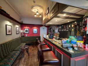 布莱克浦Raffles Hotel的餐厅内带绿色座椅的酒吧