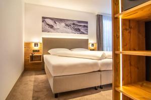 伊施格尔Hotel Garni Waldschlössl的一间卧室配有一张带白色床单的大床