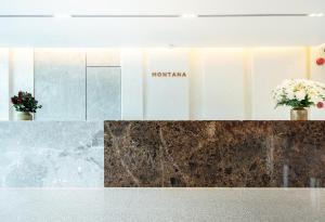 曼谷Montana Bangkok Hotel & Residence SHA Extra Plus的墙上有两瓶花的大堂