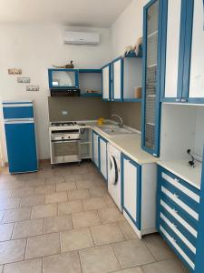 维拉诺瓦casa patrizia的厨房配有蓝色橱柜、水槽和洗碗机。