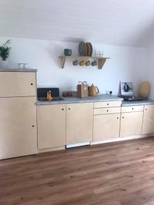 拉辛赫Castledarcy Glamping的厨房铺有木地板,配有白色橱柜。